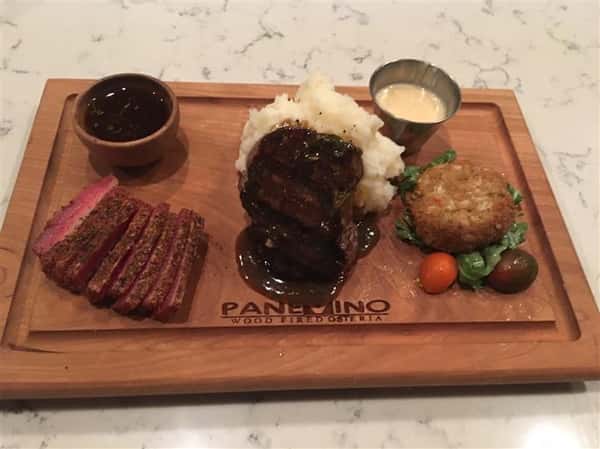 platter with sliced steak, mashed potatoes and sauce