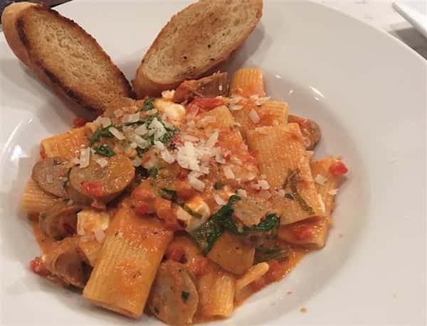 pasta with sauce and sausage with bread