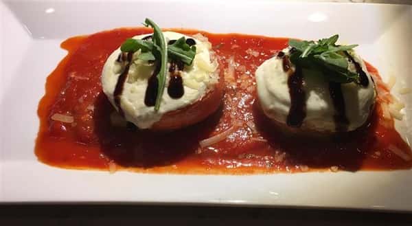 stuffed tomatoes with cheese, sauce and herbs