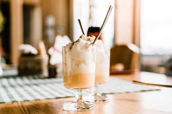 Refreshing milkshakes topped with whipped cream in a cozy café. Perfect for dessert lovers.