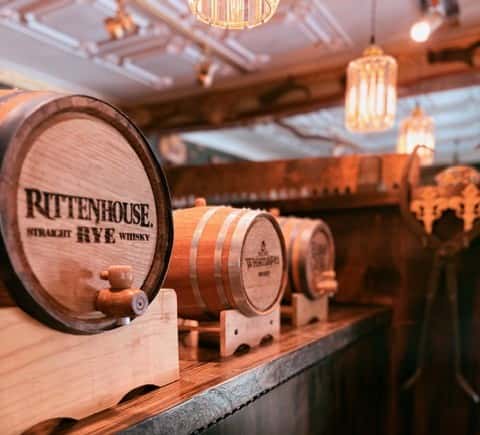 Barrel aged cocktail barrels displayed on top of bar