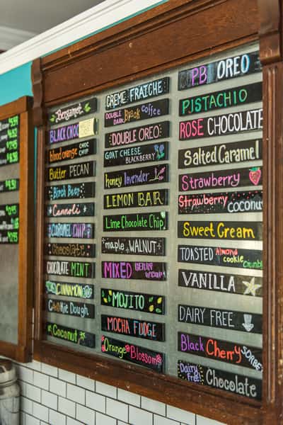 Chalkboard ice cream menu featuring creative flavors like pistachio, salted caramel, and strawberry, artisan ice cream shop interior