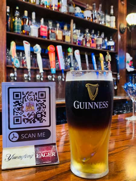 a tall glass of beer at the bar