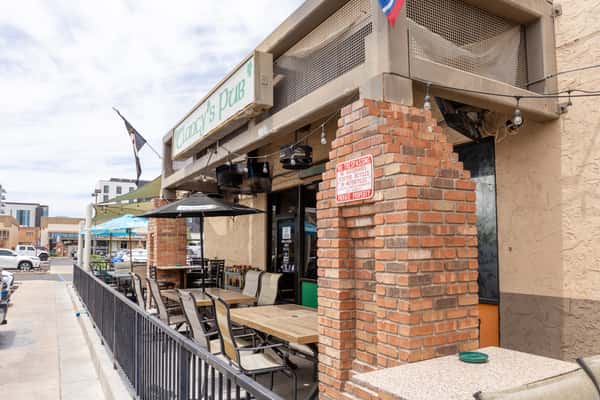 Patio dining entrance with outdoor seating and sports bar signage, ideal for casual drinks and dining.