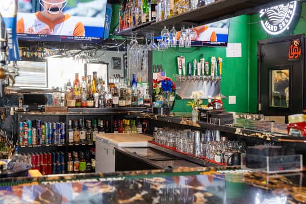 Full-service sports bar with liquor display, draft beer selection, and multiple TVs for game-day viewing.
