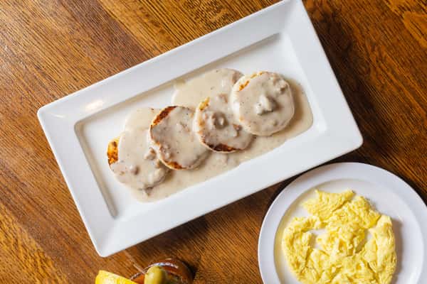 Southern-style biscuits and gravy served with scrambled eggs in a hearty breakfast presentation.