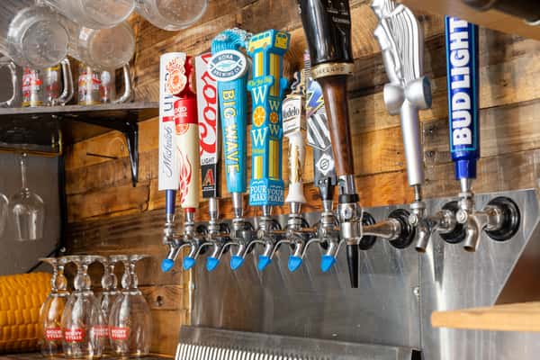 Draft beer tap wall featuring a selection of domestic and craft beers at the bar.