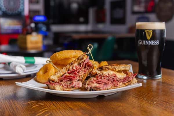 Classic Reuben sandwich stacked with corned beef, Swiss cheese, and sauerkraut, served with crispy fries.