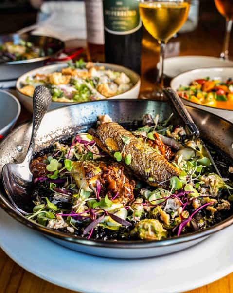 Paella was born in Valencia in the 19th century, where farmers cooked rice with vegetables and proteins like rabbit or chicken in a wide, shallow pan