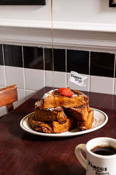 Challah French toast topped with syrup and strawberries at Famous 4th Street Delicatessen — traditional Jewish-style breakfast in Philadelphia.