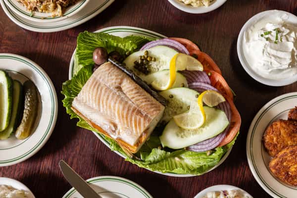 Smoked salmon platter with cucumbers, onions, and lemon at Famous 4th Street Delicatessen — Jewish-style deli favorite in Philadelphia.