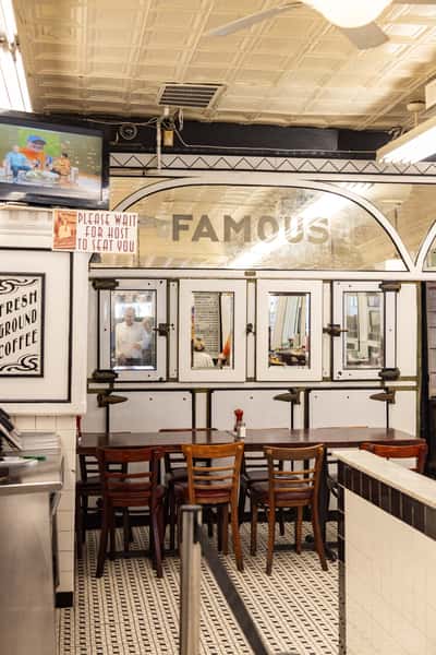 Vintage interior of Famous 4th Street Delicatessen featuring classic deli murals and seating — Philadelphia Jewish deli landmark.