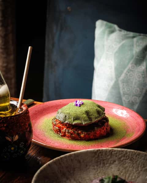 Moody interior with a saucy meat dish served on a wooden table