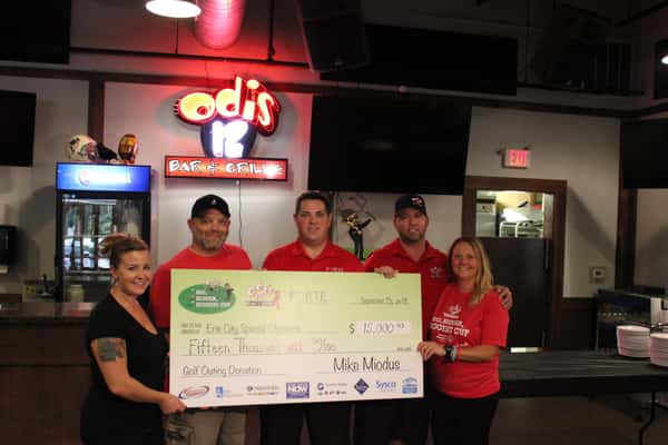 5 people holding a large check