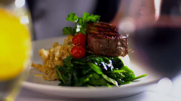 Steak sitting on a bed of greens