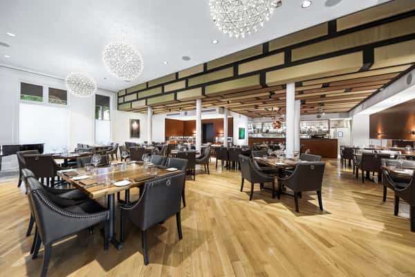 Silo Prime location's dining room with table, chairs, white tablecloths, and chandeliers