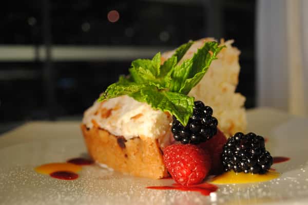 Slice of cake with fresh raspberries, blackberries and mint