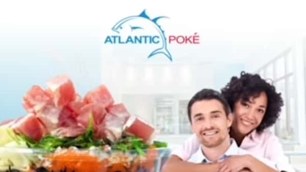A happy couple stand in an ad for an Atlantic Poké franchise, with the words "Franchise with us & become an Atlantic Poké Owner." A bowl of colorful poké sits in front of them.