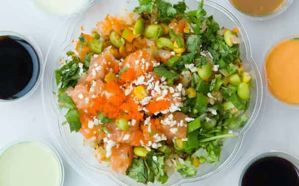 Two poke bowls overflowing with raw fish and other ingredients. Black sesame seeds top the bowls for added texture and flavor. These bowls appear to be prepared and ready to serve.