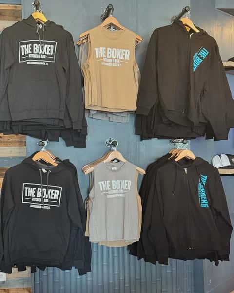 The Boxer Kitchen & Bar branded apparel display featuring hoodies, sleeveless shirts, and zip-up jackets available as restaurant merchandise in Clearwater Beach, Florida.