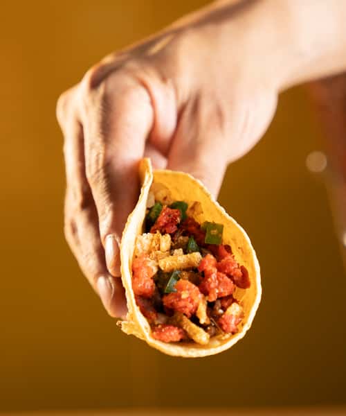 Hand holding a Taco Costeno