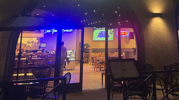 Exterior nighttime view of a restaurant with illuminated interior seating.