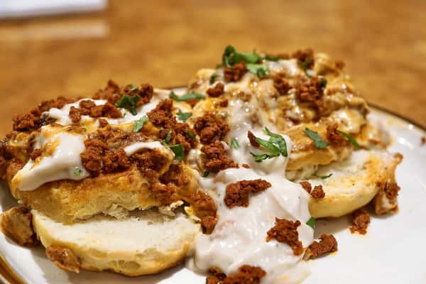 Flaky buttermilk biscuits topped with creamy white gravy, seasoned chorizo crumbles, melted cheese, and fresh cilantro for a savory Mexican breakfast twist.
