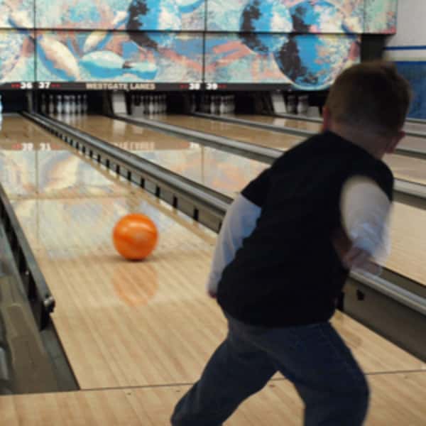 kid throwing a bowling ball down the lane