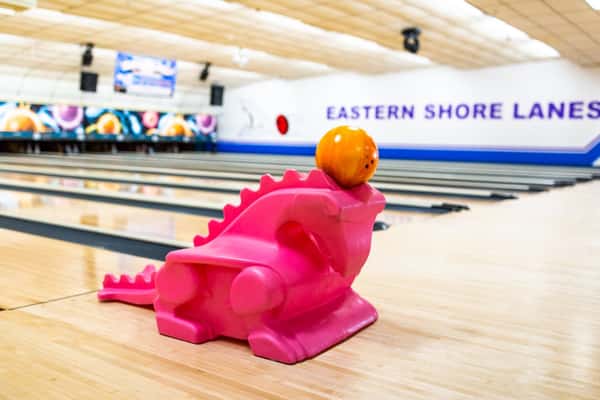 kid's bowling ramp shaped like a dinosaur with bowling ball on top