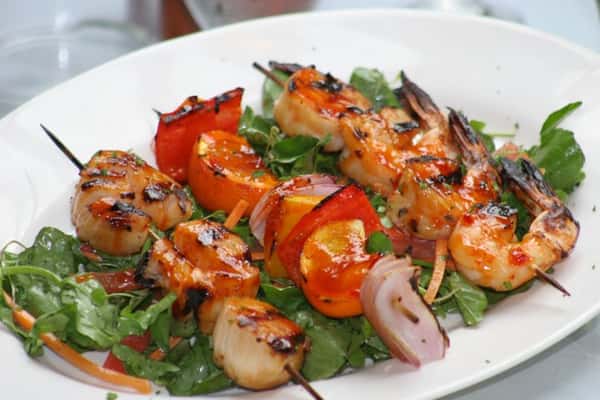Shrimp and scallop skewers on a bed of lettuce