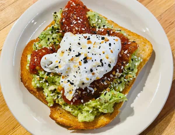 Vibrant avocado toast featuring red jam, a creamy white poached egg, and everything bagel seasoning from The Downing Bottles and Bites.