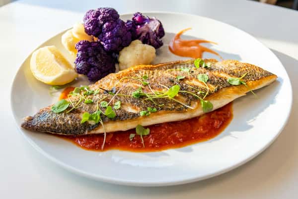 Fish dish with sauce and a side of citrus