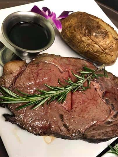 Steak with a baked potato side and sauce