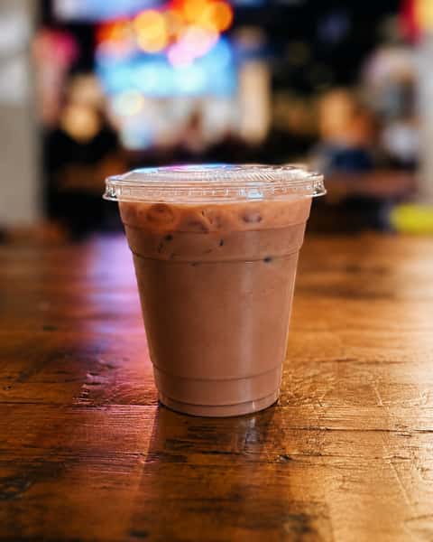 Refreshing iced Milo chocolate malt drink served in a clear cup, a popular Malaysian beverage perfect for cooling off.