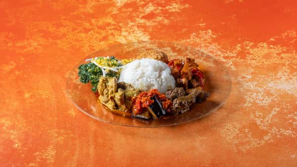 Authentic nasi lemak plate with coconut rice, fried chicken, sambal, anchovies, peanuts, cucumber, and traditional Malaysian sides.