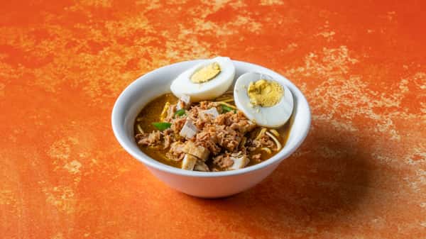 Classic Malaysian mee rebus with rich savory gravy, noodles, hard-boiled egg, and crispy toppings served in a bowl.