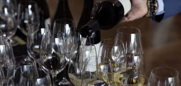 Wine being poured into rows of glasses at a winemaker dinner at 360 Bistro in Belle Meade, Nashville