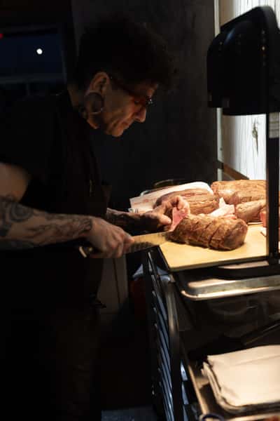 Chef carving roasts tableside at a winemaker dinner at 360 Bistro in Belle Meade, Nashville