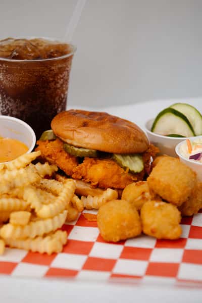 Fried chicken sandwich platter served with hush puppies, crinkle cut fries, coleslaw, and dipping sauce.