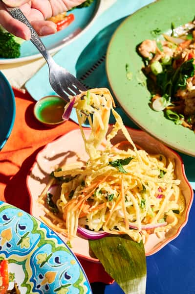 Our Mango Salad: freshness in every bite. Juicy mango, carrot, red onion, mint, and cilantro. All tossed in our addictive roasted rice vinaigrette. Light, and full of Thai zing.