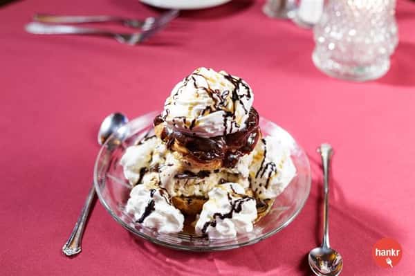 A dessert with chocolate, whipped cream and chocolate syrup