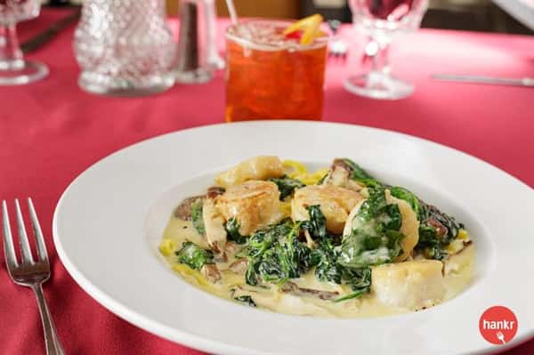 cooked scallops and spinach over sauce