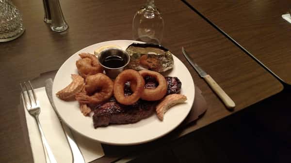 Grilled steak served with onion rings