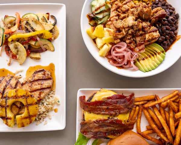 Close up of a plated grilled entrée with sides on a white plate.