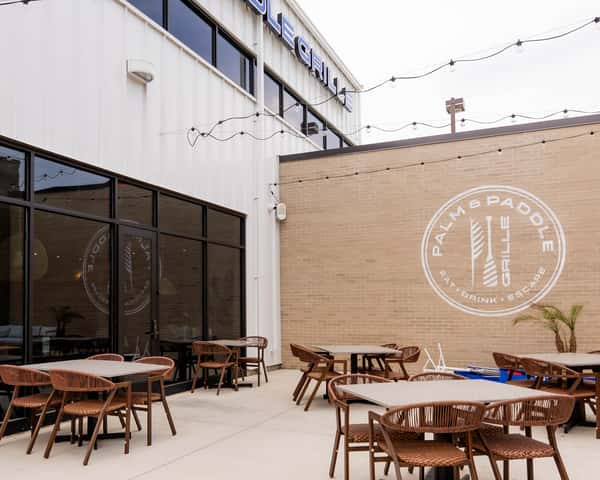 Exterior wall of a building with a large circular logo painted on brick.