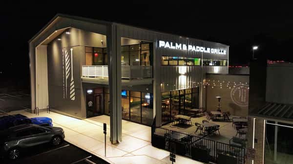 Night exterior of a modern restaurant building with illuminated signage.