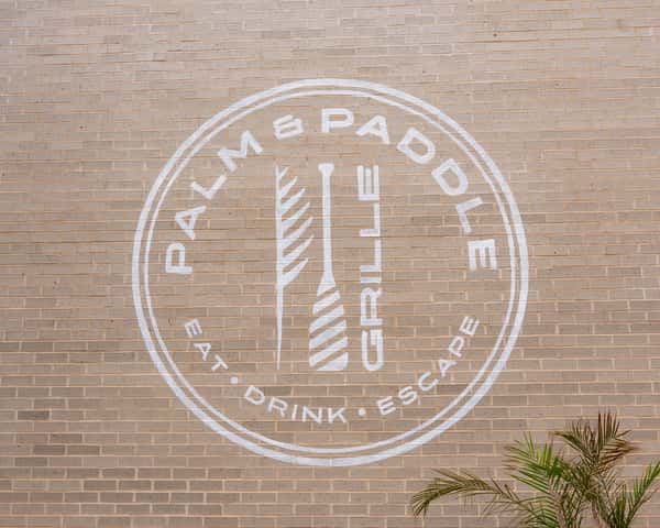 Circular restaurant logo painted on a brick wall.