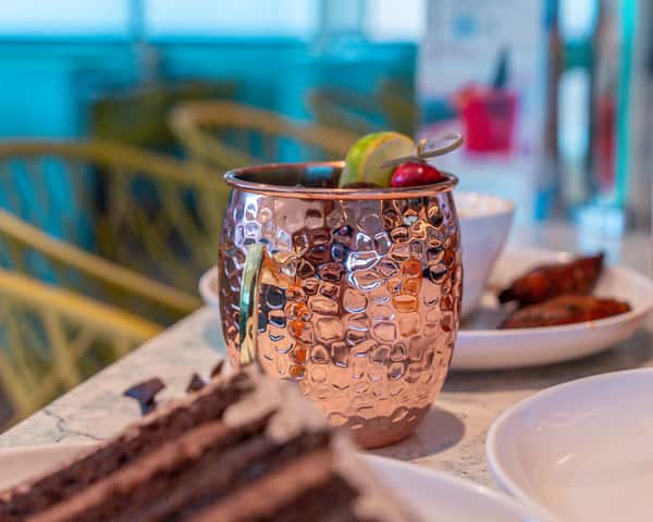 Close up of a textured copper mug style drink on a table.