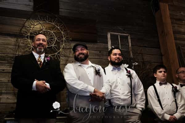 groomsmen smiling with the groom standing at the alter