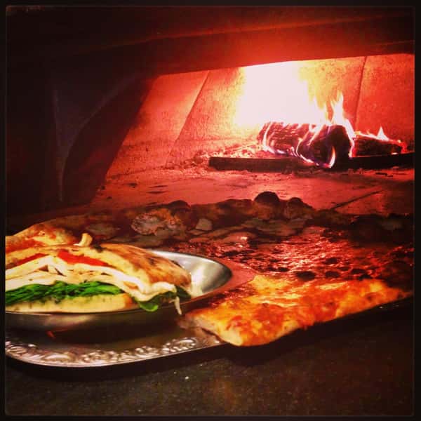Food going into a wood fire oven